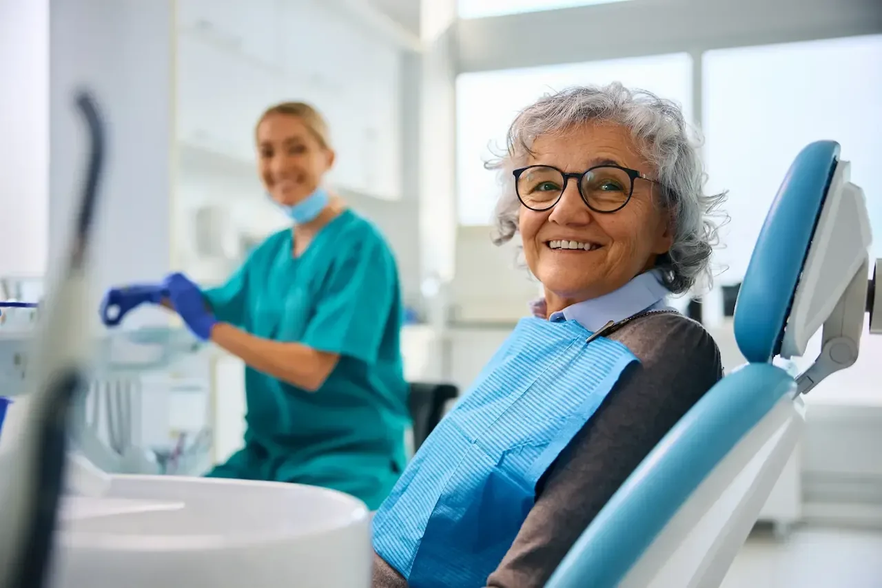 Smilende pasient i tannlegestolen hos Sentrum Tannklinikk